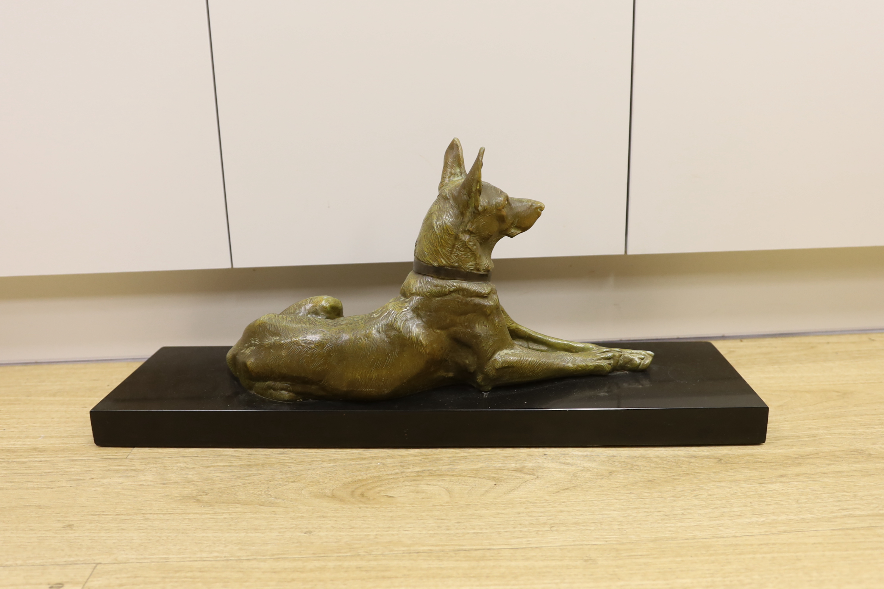 After Maximilien Louis Fiot (1886-1953). A French Art Deco bronzed spelter model of a recumbent German Shepherd, 70cm long